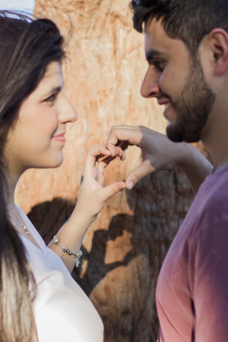 Casal fazendo um coração com as mãos